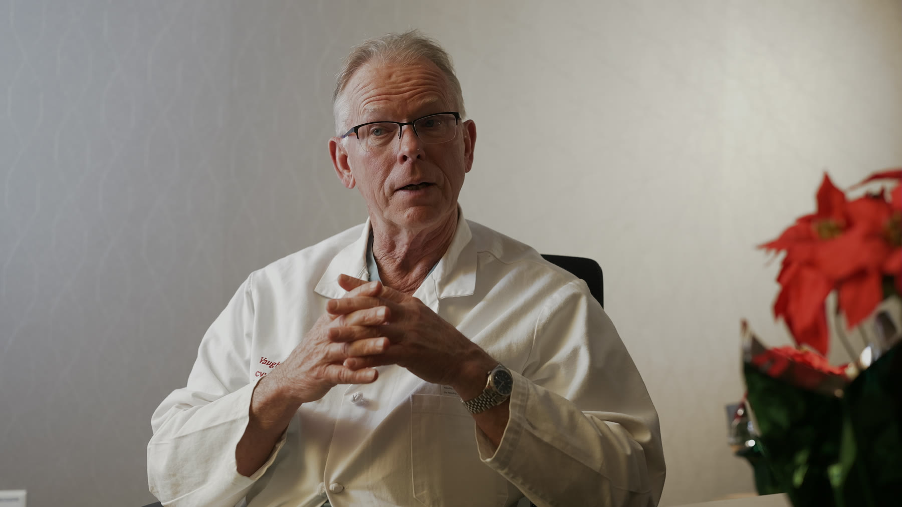 Dr. Vaughn Starnes, in his white coat, speaks during an interview in his office.